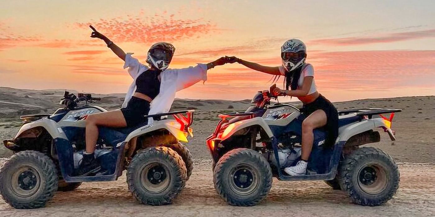 Quad biking in Agafay Desert with rocky terrain and Atlas mountains